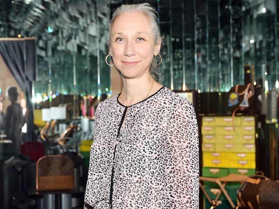 Alexandra Grant, wearing a patterned black and white dress, poses at the Louis Vuitton x Opening Ceremony fashion show in 2019.