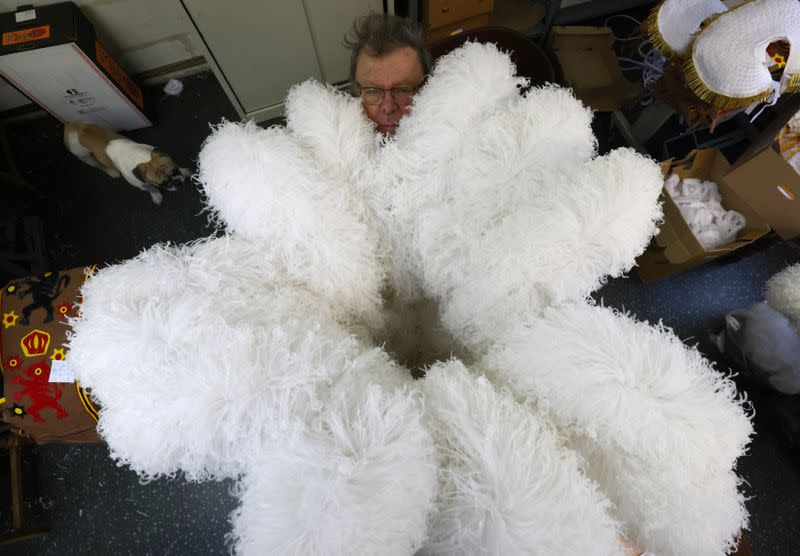 Louis Kersten, adjusts an ostrich feather hat in his workshop in Binche