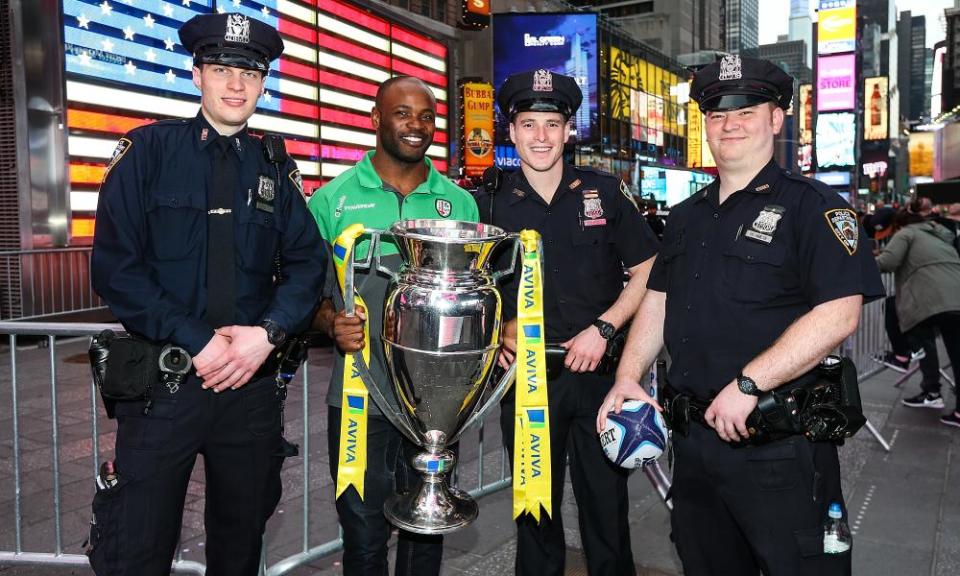 Topsy Ojo of London Irish poses with the Premiership trophy and some NYPD cops during the buildup to last year’s game against Saracens in New Jersey.