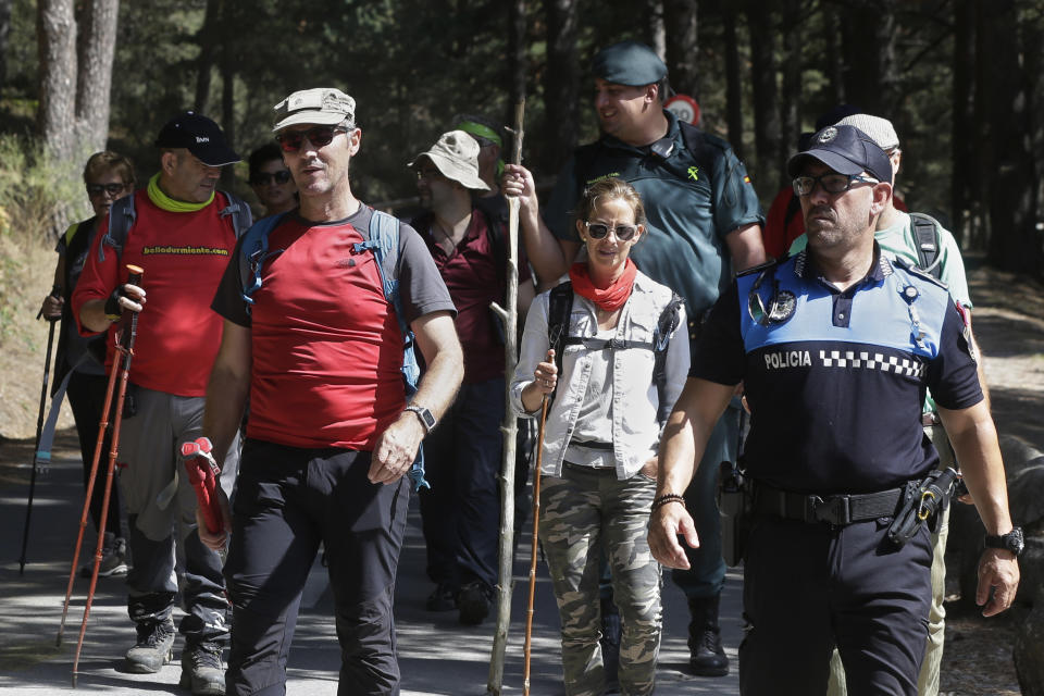 Volunteers walks with a civil guard and a police officer after searching in woodland area in Cercedilla, just outside of Madrid, Spain, Tuesday, Sept. 3, 2019. A search squad of hundreds is combing a mountainous area outside Madrid 11 days after former alpine ski racer and Olympic medalist Blanca Fernandez Ochoa went missing.(AP Photo/Paul White)