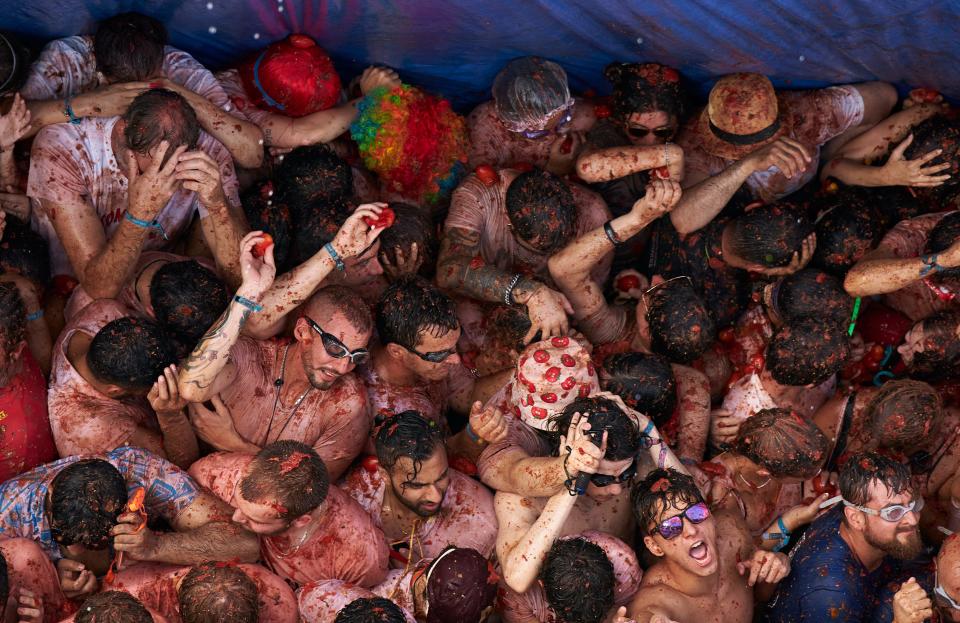 Revellers covered in tomato pulp while participating the annual Tomatina festival on August 31, 2022 in Bunol, Spain. The world's largest food fight festival, La Tomatina, consists of throwing overripe and low-quality tomatoes at each other.