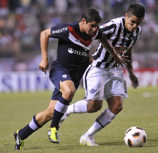 (Archivo) El defensa peruano de la Universidad de San Martin Aldo Corzo (I) traslada el balón bajo la marca del Víctor Ayala, del paraguayo Libertad, durante un partido por la Copa Libertadores disputado el 08 de marzo de 2011 en Asunción. (AFP | norberto duarte)