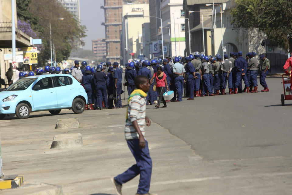 Armed Riot police patrol on a street, in Harare, Friday, Aug. 24, 2018. Zimbabwe's constitutional court was set to rule Friday afternoon on the main opposition's challenge to the results of last month's historic presidential election. Security was tight in the capital, Harare, as the court will determine whether President Emmerson Mnangagwa's narrow victory is valid. The opposition claims vote-rigging and seeks either a fresh election or a declaration that its candidate, 40-year-old Nelson Chamisa, won. (AP Photo/Tsvangirayi Mukwazhi)