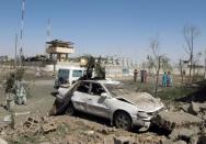 Afghan security personnel gather at the site of a truck bomb targeting police headquarters in Lashkar Gah on June 30, 2015 during the Taliban's annual summer offensive