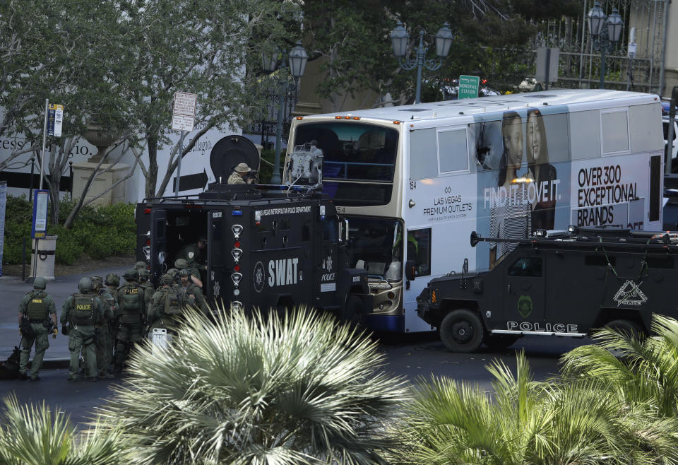 Las Vegas SWAT officers surround a bus along Las Vegas Boulevard, Saturday, March 25, 2017, in Las Vegas. Police say part of the Strip has been closed down after a shooting. (AP Photo/John Locher)