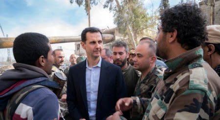 FILE PHOTO: Syrian President Bashar al-Assad meets with Syrian army soldiers in eastern Ghouta, Syria, March 18, 2018. SANA/Handout via REUTERS