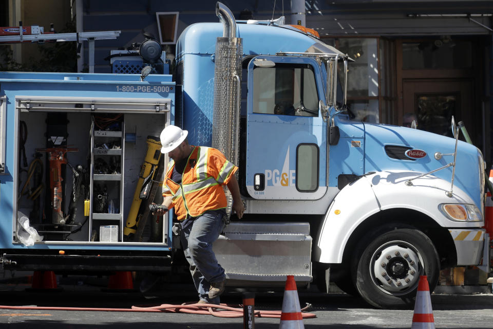 In this photo taken Aug. 15, 2019, a Pacific Gas & Electric worker exits a truck in San Francisco. Pacific Gas and Electric Co. bondholders and wildfire victims have joined forces and proposed their own reorganization plan as they try to wrest control of the bankrupt company from its stockholders. The San Francisco Chronicle reports the two groups told PG&E's bankruptcy judge Thursday, Sept. 19, 2019, their proposal would include a $24 billion settlement to pay everyone owed money because of fires started by the company's power lines in recent years. (AP Photo/Jeff Chiu)