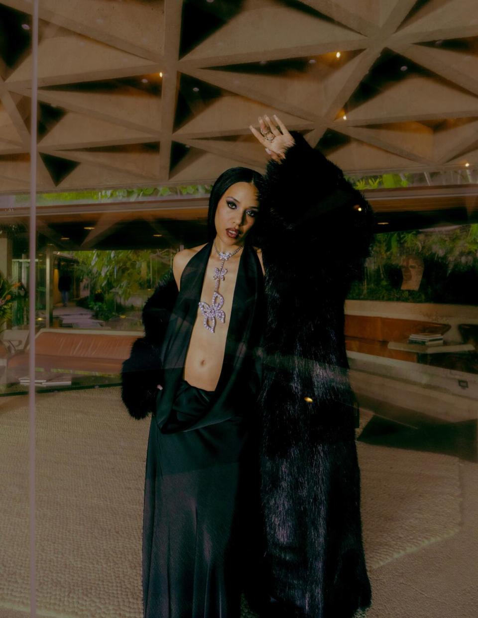 May in a floor-length black dress and fur coat at the Sheats-Goldstein residence.