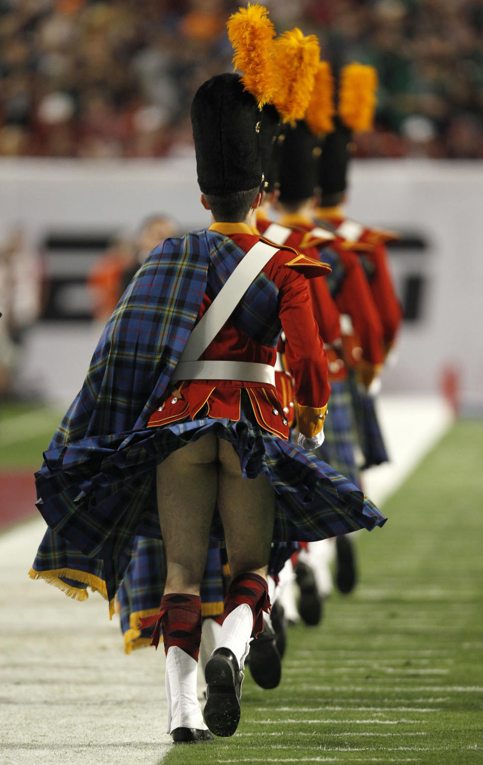 A member of the Notre Dame Fighting Irish band has his kilt blow up before the start of the NCAA BCS National Championship college football game in Miami, Florida January 7, 2013. REUTERS/Jeff Haynes (UNITED STATES - Tags: SPORT FOOTBALL)