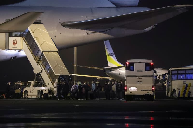 Passengers of the cruise ship Diamond Princess, where dozens of passengers were tested positive for coronavirus, board their plane at Haneda airport in Tokyo