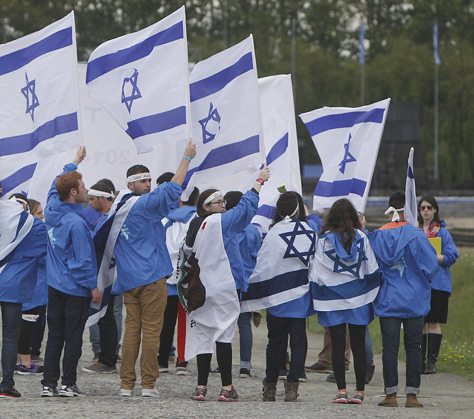 Young jewish people from Israel and other countries march in silence between the two parts of Auschwitz-Birkenau, the Nazi German death camp, in an annual march of the living in Oswiecim, Poland, on Monday, April 28, 2014, which is held in memory of some 6 million Jews killed during the Holocaust. This year, the march honors some 430,000 Hungarian Jews killed in Birkenau gas chambers in 1944. (AP Photo/Czarek Sokolowski)