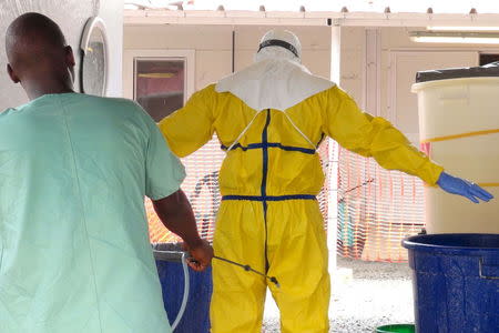 A health worker gets sprayed with disinfectant in an Ebola virus treatment center in Conakry, Guinea, November 17, 2015. REUTERS/Saliou Samb