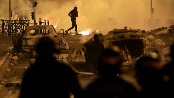 PHOTO: A demonstrator runs on the third night of protests sparked by the fatal police shooting of a 17-year-old driver in the Paris suburb of Nanterre, France, on June 30, 2023. (Aurelien Morissard/AP)