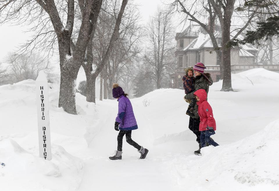 The Motz family walks through blowing snow as weather conditions worsen on Wednesday, February 22, 2023, in Sioux Falls.