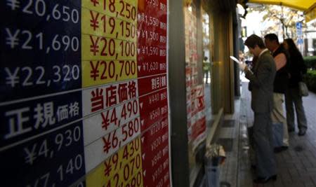 People look at the prices of tickets outside a ticket shop at the Ginza shopping district in Tokyo October 31, 2013. REUTERS/Yuya Shino