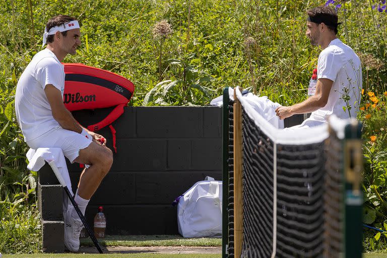 Roger Federer charla con Grigor Dimitrov en el Aorangi Park de Wimbledon