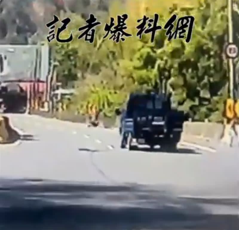 騎士回頭看小貨車，未注意前方路況，連人帶車自撞護欄。(圖／翻攝自記者爆料網)