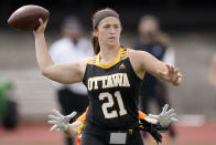 Ottawa quarterback Madysen Carrera passes to a teammate while pressured by a Midland defender during an NAIA flag football game in Ottawa, Kan., Friday, March 26, 2021. The National Association of Intercollegiate Athletics introduced women's flag football as an emerging sport this spring. (AP Photo/Orlin Wagner)