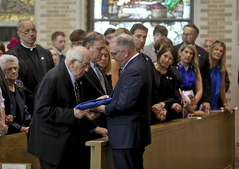 Louisiana Governor John Bel Edwards presents the folded state flag from her casket to her husband Raymond during a Celebration of Life Interfaith Service for former Louisiana Gov. Kathleen Babineaux Blanco, at St. Joseph Cathedral in Baton Rouge, La., Thursday, Aug. 22, 2019. Thursday was the first of three days of public events to honor Blanco, the state's first female governor who died after a years long struggle with cancer.(AP Photo/Michael Democker, Pool)