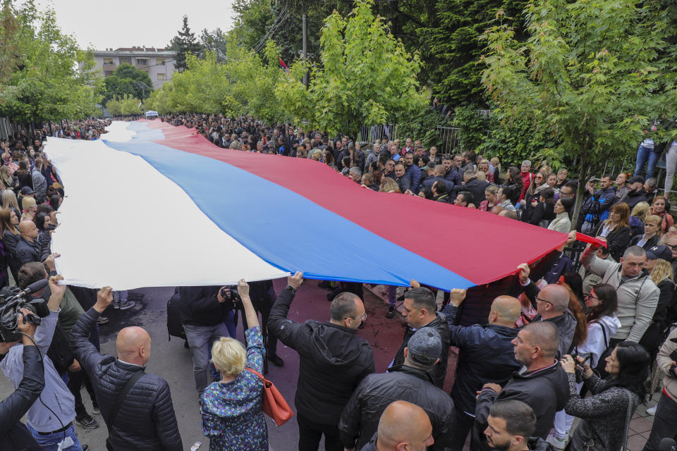 People hold a giant Serbian flag during a protest in front of the city hall in the town of Zvecan, northern Kosovo, Wednesday, May 31, 2023. Hundreds of ethnic Serbs began gathering in front of the city hall in their repeated efforts to take over the offices of one of the municipalities where ethnic Albanian mayors took up their posts last week. (AP Photo/Bojan Slavkovic)
