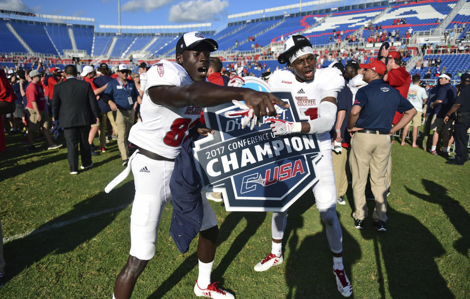 nam FILE - Florida Atlantic wide receiver Tavaris Harrison (82) and defensive back Herb Miller (21) celebrate winning the Conference USA championship NCAA college football game against North Texas, Saturday, Dec. 2, 2017, in Boca Raton, Fla. Tom Herman was away from the college football sideline for two years before he realized that he had to get back. Florida Atlantic called at the right time. Herman is taking over in Boca Raton and now leads an Owls program that is seeking to return to the level it was at during Lane Kiffin's wildly successful stay at the school. Herman has never had a losing season as a head coach. (Jim Rassol/South Florida Sun-Sentinel via AP, File)