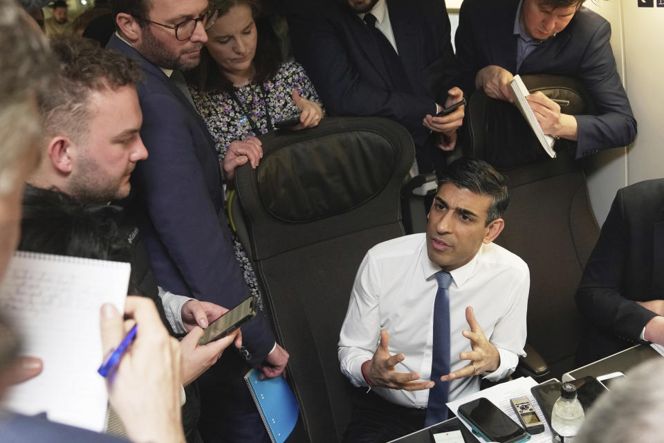 Britain's Prime Minister Rishi Sunak, bottom right, talks to media in a train during his travelling to France, Friday, March 10, 2023. French President Emmanuel Macron and British Prime Minister Rishi Sunak going to meet Friday in Paris in a summit aimed at mending relations following post-Brexit tensions, improving military and business ties and toughening efforts against Channel migrant crossings. (AP Photo/Kin Cheung, Pool)