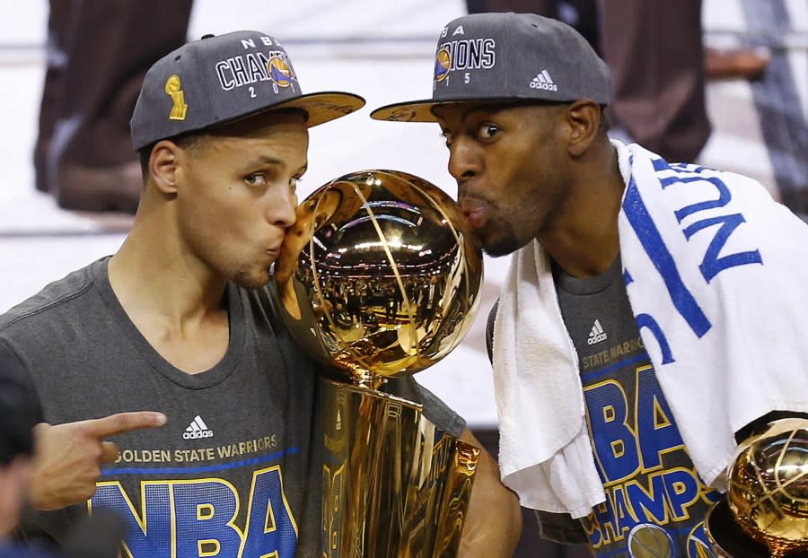 Golden State Warriors Stephen Curry, left, and Andre Iguodala kiss the Larry O’Brien Trophy after defeating the Cleveland Cavaliers 105-97 in Game 6 of basketball’s NBA Finals in Cleveland, June 17, 2015. (AP Photo/Paul Sancya, File)