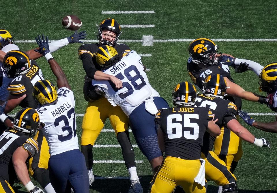 Michigan defensive lineman Mazi Smith hits Iowa quarterback Spencer Petras as he releases a throw last season. Stuffing the run, not rushing the passer, is Smith's calling card. "Football's taken care of me my whole life," he said Thursday night. "I don't know what I'd do if I couldn't put that helmet on and hit somebody."