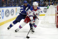 New York Rangers defenseman Nils Lundkvist (27) carries the puck in front of Tampa Bay Lightning left wing Gabriel Fortier (82) during the second period of an NHL hockey game Friday, Dec. 31, 2021, in Tampa, Fla. (AP Photo/Chris O'Meara)