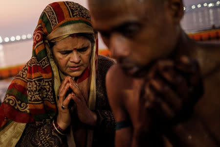 Devotees pray after taking a holy dip at Sangam, the confluence of the Ganges, Yamuna and Saraswati rivers, during "Kumbh Mela", or the Pitcher Festival, in Prayagraj, previously known as Allahabad, India, January 16, 2019. REUTERS/Danish Siddiqui