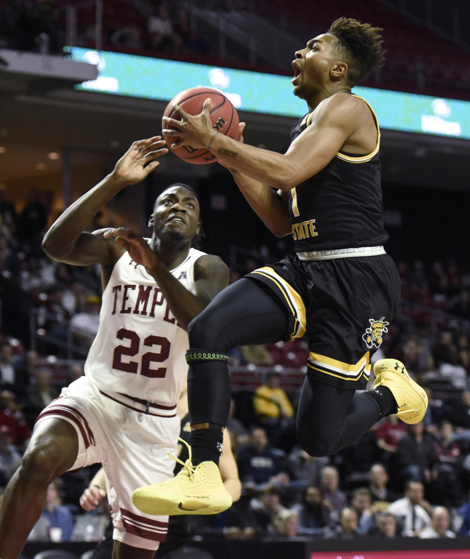 Wichita State's Tyson Etienne (1) drives to the basket as Temple's De'Vondre Perry (22) defends during the first half of an NCAA college basketball game Wednesday, Jan. 15, 2020, in Philadelphia. (AP Photo/Michael Perez)