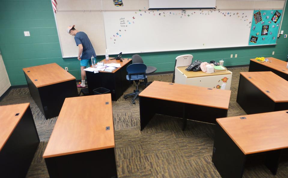 Ryan Humphreys, 18, cleans a classroom whiteboard while working with ServErie volunteers at Iroquois Elementary School in Lawrence Park Township on Friday.