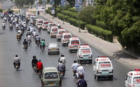 Ambulances carry the bodies of the victims of Wednesday's attack on a bus to a graveyard for burial in Karachi, Pakistan, May 14, 2015. REUTERS/Akhtar Soomro