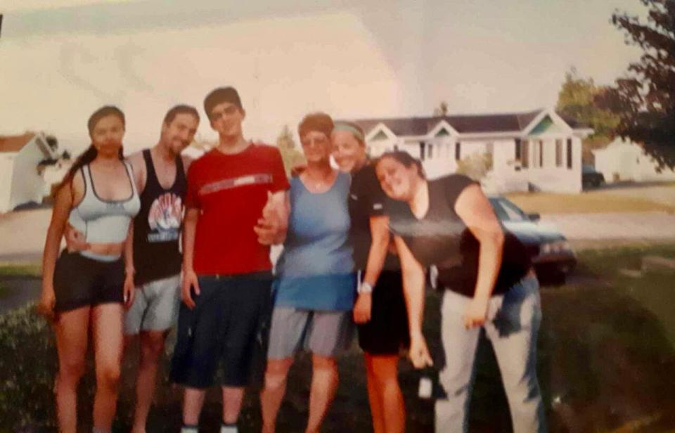 Marie-France Santerre, centre, pictured in printed photo from 2000 with some of the students she welcomed into her home. 