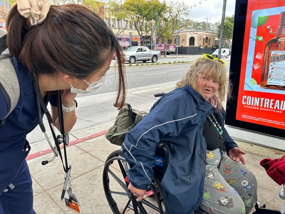 PHOTO: Isabelle Peng tries to talk with a homeless woman, Lisa Vernon, after receiving a call about someone in crisis on the streets.  (Angela Hart/KFF Health News)