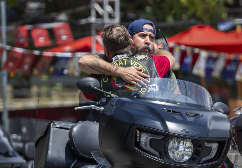 Trabuco Canyon, CA - September 01: Members of the Combat Veterans Association motorcycle club hug after arriving on their motorcycles to return to the scene and offer comfort to fellow bikers and friends after last week's mass shooting at Cook's Corner in Trabuco Canyon Friday, Sept. 1, 2023. "A I got off my bike, I felt the presence of the Holy Spirit and had to raise my arms in prayer" Lopez said. "I was praying to lift their spirit and give them peace in Heaven and to bring this building peace, love and happiness", Lopez said. Cook's Corner, the Trabuco Canyon bar where a gunman killed three people and injured six others before being fatally shot by Orange County sheriff's deputies, reopens, with the manager saying she wants to ``bring the family back together.'' In a video posted Thursday on Facebook, Cook's Corner general manager Rhonda Palmeri said she's been asked by many people when the venue will reopen following the Aug. 23 shooting.(Allen J. Schaben / Los Angeles Times)