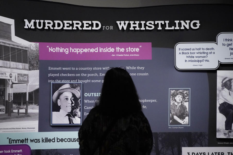 Lotte Dula of Denver, Colo., examines a panel of the "Emmett Till and Mamie Till-Mobley Let The World See" exhibit with photographs of a young Till, left, and a photograph of Carolyn Bryant, the white woman who accused the teenager of making improper advances before he was lynched in Mississippi in 1955, Thursday, April 27, 2023, at the Two Mississippi Museums in Jackson, Miss. Carolyn Bryant Donham died Tuesday, April 25 in hospice care in Louisiana. She was 88. (AP Photo/Rogelio V. Solis)