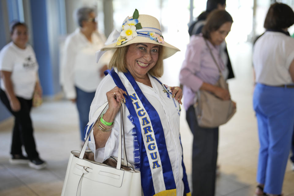 Sandra Salinas wears the colors of Nicaragua's flag as parishioners arrive for Mass at St. Agatha catholic church, which has become the spiritual home of the growing Nicaraguan diaspora, Sunday, Nov. 5, 2023, in Miami. For the auxiliary bishop of Managua, one of his concelebrant priests and many in the pews who have had to flee or were exiled from Nicaragua recently, the Sunday afternoon Mass at the Miami parish is not only a way to find solace in community, but also to keep pushing back against the Ortega regime's violent suppression of all critics, including many Catholic leaders. (AP Photo/Rebecca Blackwell)