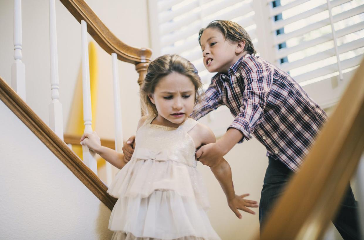 Hurting a sibling is not the same thing as healthy rivalry. <a href="https://www.gettyimages.com/detail/photo/boy-grabbing-girls-arm-on-stairs-royalty-free-image/588312516" rel="nofollow noopener" target="_blank" data-ylk="slk:Glasshouse Images/The Image Bank via Getty Images;elm:context_link;itc:0;sec:content-canvas" class="link ">Glasshouse Images/The Image Bank via Getty Images</a>