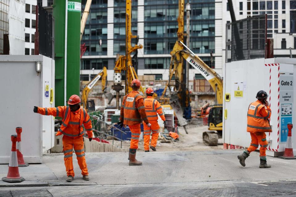 Construction workers are seen at a site entrance in London on May 11, 2020: REUTERS