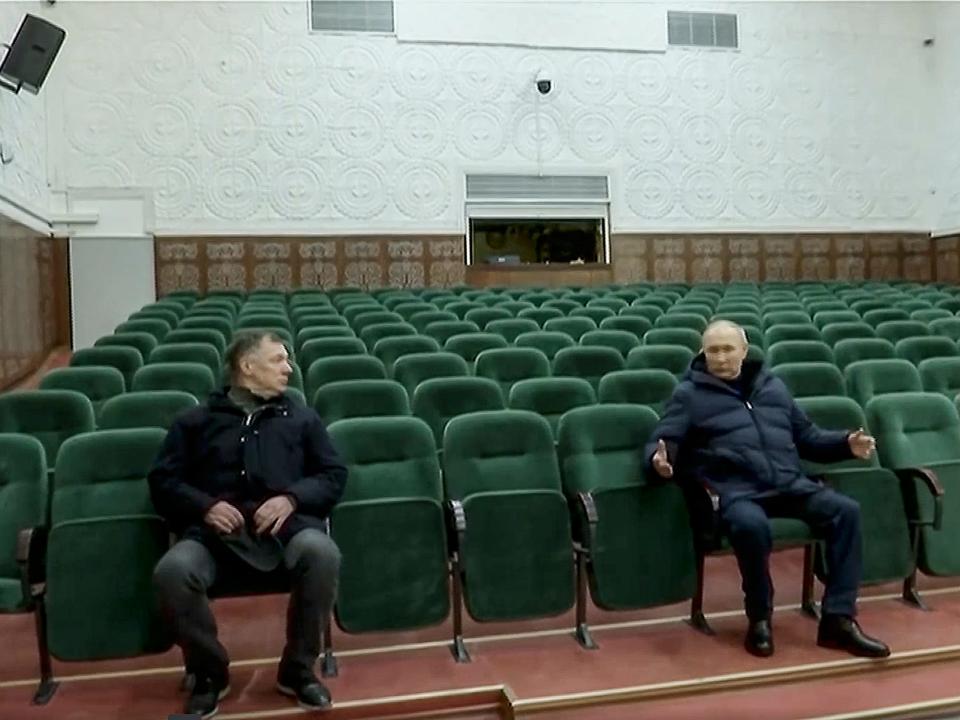 Russian President Vladimir Putin (R) visits a recently renovated theater in Mariupol.