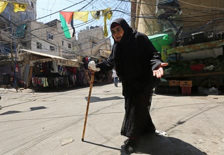 An elderly woman gestures as she walks at the Burj al-Barajneh refugee camp in Beirut