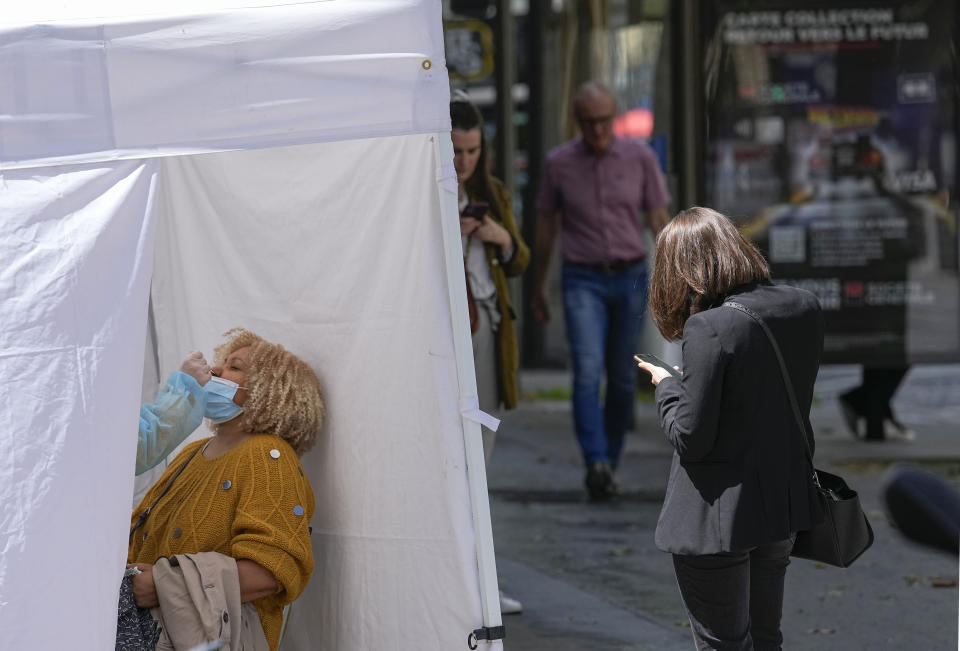 A medical technician administers nasal swabs at a mobile testing site in Paris, Monday, July 12, 2021. France's President Emmanuel Macron is hosting a top-level virus security meeting Monday morning and then giving a televised speech Monday evening, the kind of solemn speech he's given at each turning point in France's virus epidemic.(AP Photo/Michel Euler)