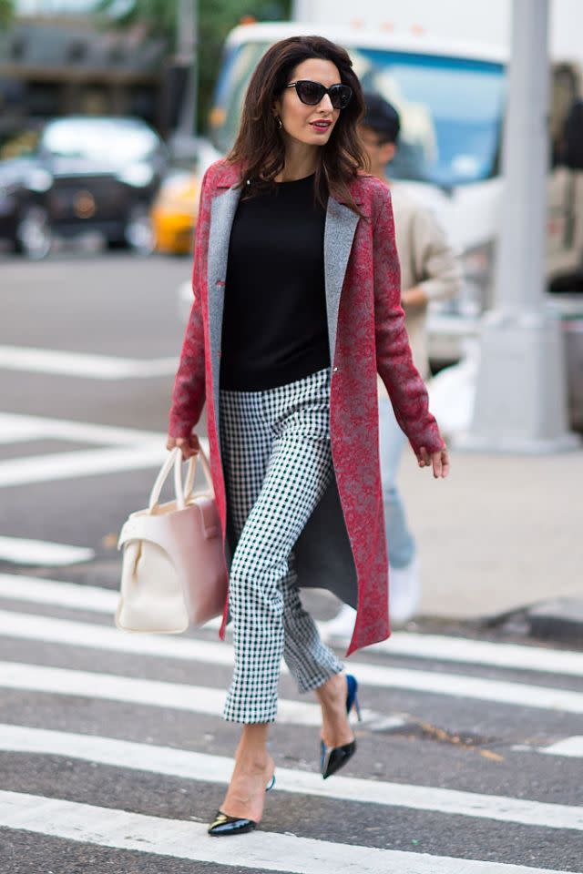 <p>A. Clooney prouve à quel point il est facile de mélanger les motifs au bureau, vêtue d’un pantalon à carreaux et d’un incroyable manteau en tissu brocart. Elle a cependant accessoirisé le tout de manière neutre afin de ne pas en faire trop non plus, optant ainsi pour des chaussures plates pointues, un sac blanc et des lunettes de soleil style « yeux de chat ». (Photo par Michael Stewart/GC Images)</p>