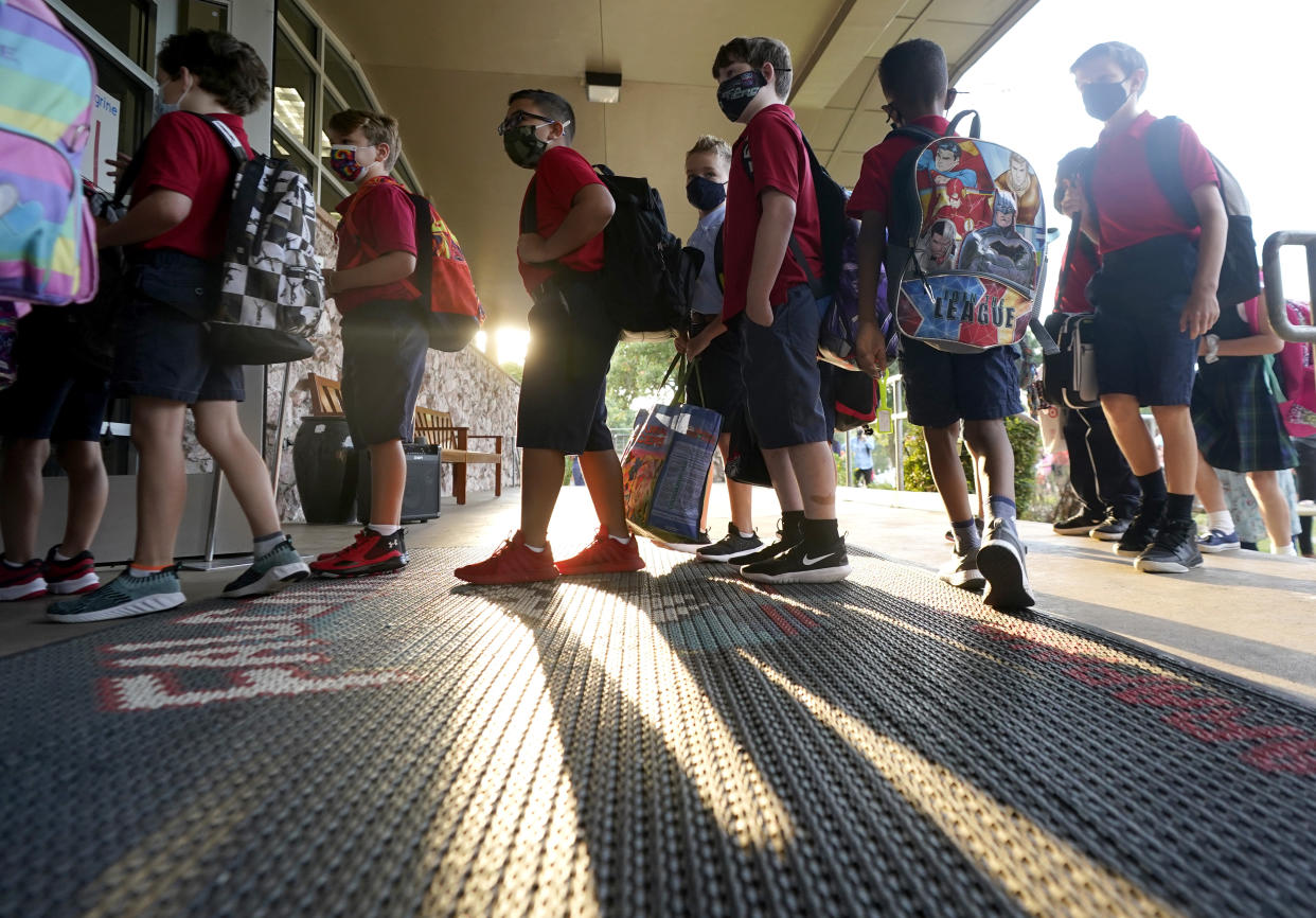 Elementary school students line up for the first day of classes in Richardson, Texas, on Monday, despite Gov. Greg Abbott's executive order banning mask mandates by local officials. The Richardson Independent School District is now requiring masks for students.