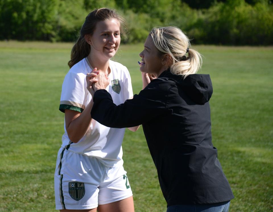 Madalyn Zaleski is greeted by St.  Mary Catholic Central coach Laura Perry as she comes off the field at halftime during a Division 4 District game against Detroit Cristo Rey Thursday.