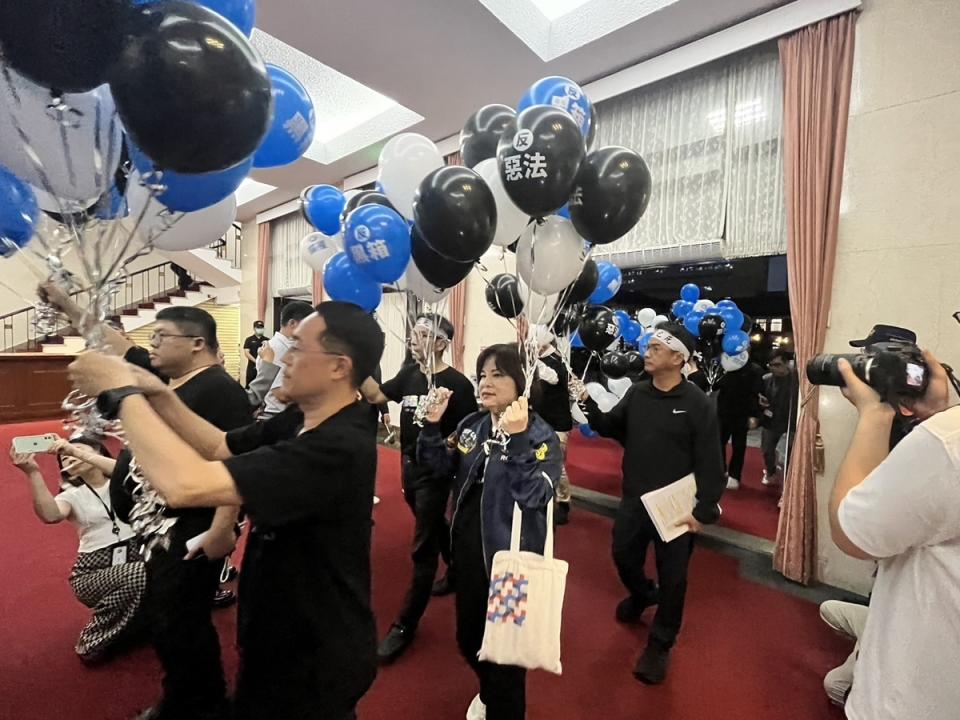  民進黨團手舉氣球高喊「反黑箱、反擴權、退回重審」口號進入議場。 圖：金大鈞/攝 