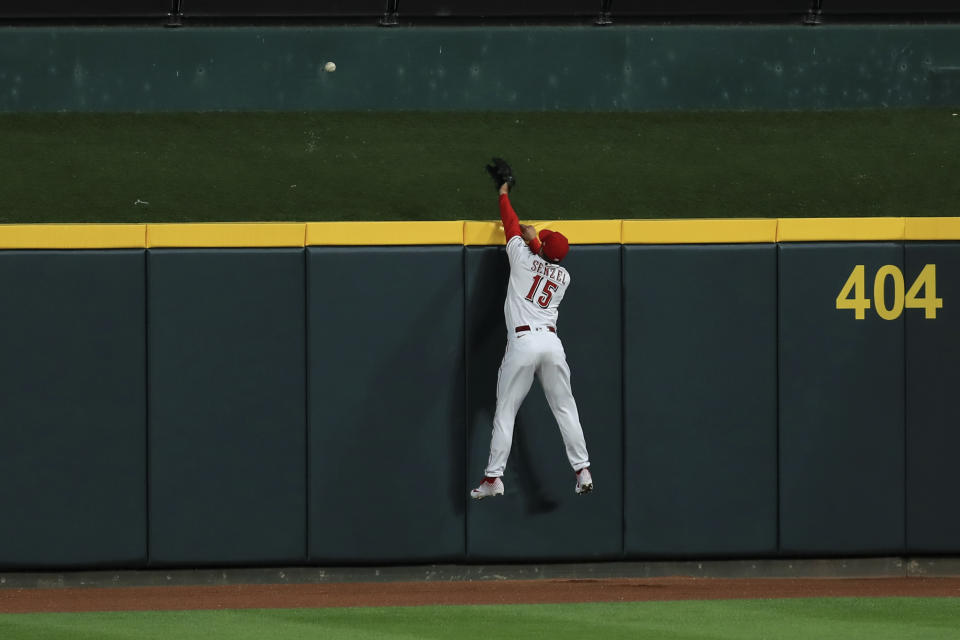 Cincinnati Reds' Nick Senzel leaps at the wall and is unable to catch the ball hit by Milwaukee Brewers' Tyrone Taylor for a solo home run in the fifth inning during a baseball game in Cincinnati, Tuesday, Sept. 22, 2020. (AP Photo/Aaron Doster)