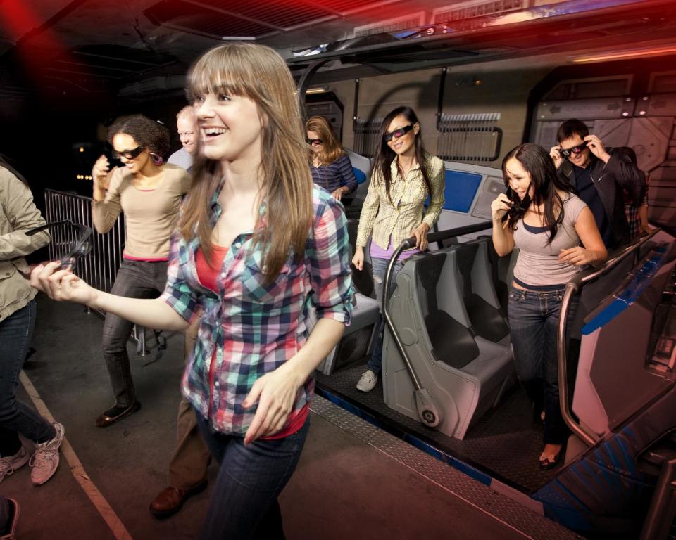 In this undated image released by Universal Studios Hollywood, riders exit the "Transformers the Ride: 3D," attraction at Universal Studios Hollywood in Los Angeles. Debuting May 25 at Universal Studios Hollywood, the ride, based on the film franchise, offers motion-simulator vehicles and 3D high definition video. (AP Photo/Universal Studios Hollywood)