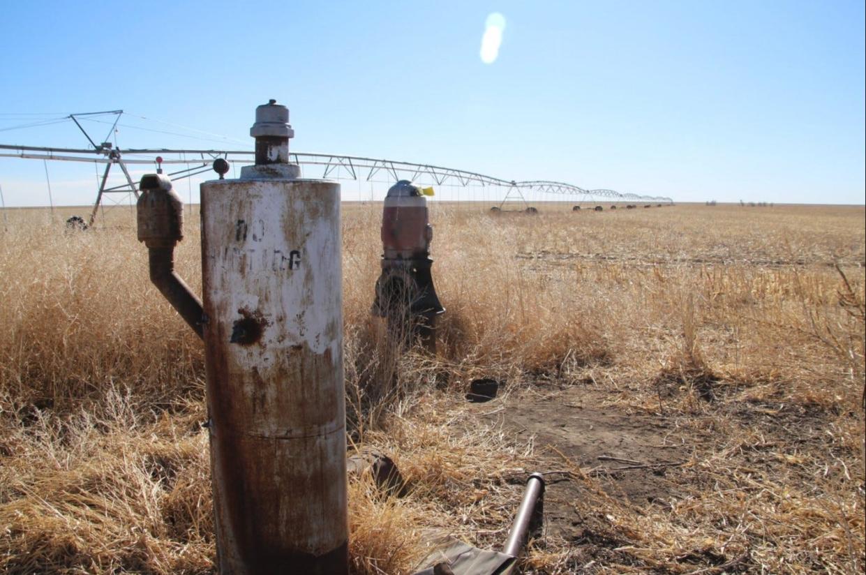 An old water well stands next to a center pivot irrigation system in a Morton County field. This southwest corner of Kansas has been experiencing extreme drought since last fall.